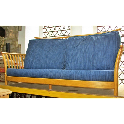 1180 - A pale Ercol wing settee with blue upholstered cushions