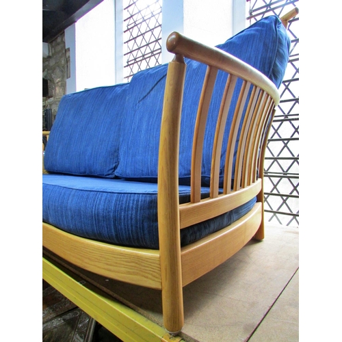 1180 - A pale Ercol wing settee with blue upholstered cushions