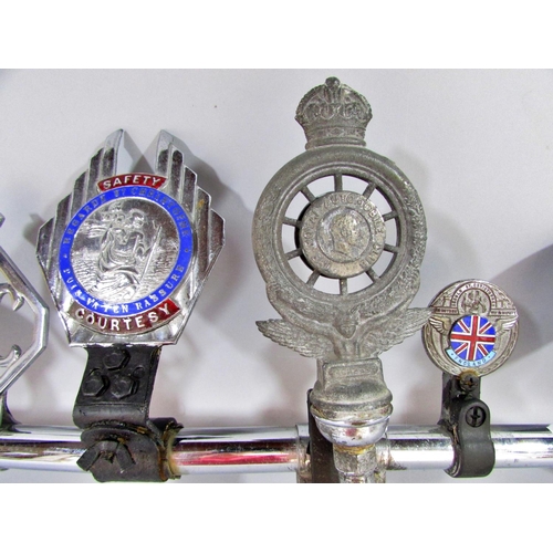 511 - A chromium bar with seven vintage car badges attached, three St Christopher, two RAC, Scotland, Corn... 