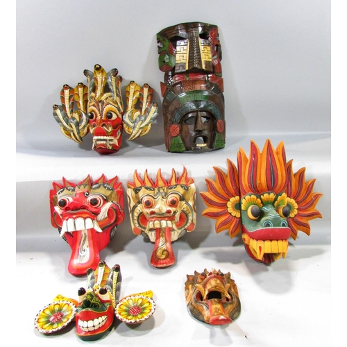 525 - A mixed selection of Sri Lankan and Balinese colourful carved masks, and a single mask Aztec Mayan m... 