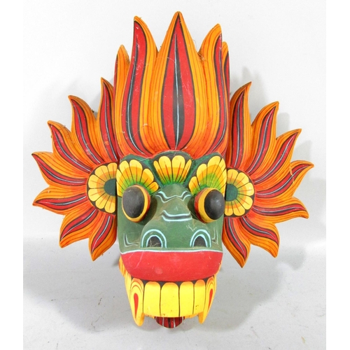 525 - A mixed selection of Sri Lankan and Balinese colourful carved masks, and a single mask Aztec Mayan m... 