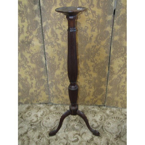 1313 - A fluted carved mahogany tripod torchere, 122cm high.