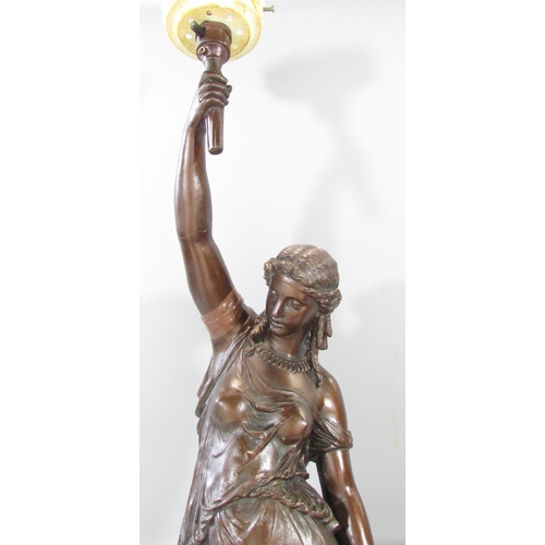 451 - A bronzed metal table lamp in the form of a classical woman holding aloft a lamp, raised on a circul... 