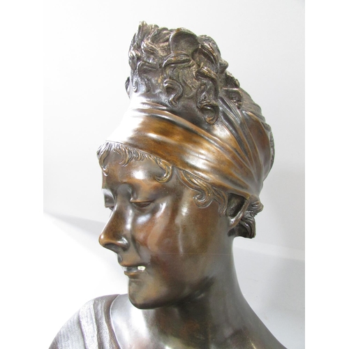 453 - A bronzed bust of a flirtatious woman raised on a marble plinth, bearing a small plaque Mme- Reeamie... 