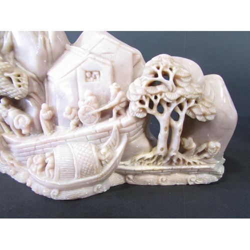 478 - Two Chinese soapstone carvings, on a pinkish colour of people and buildings on a hillside, the other... 