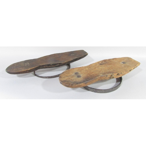 500 - A pair of 18th century iron and wood mud boots, lacking leather straps, (one as found) 25cm long.