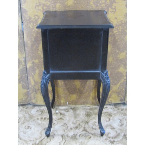 1353 - A reproduction black framed carved upholstered elbow chair together with an associated bedside cupbo... 