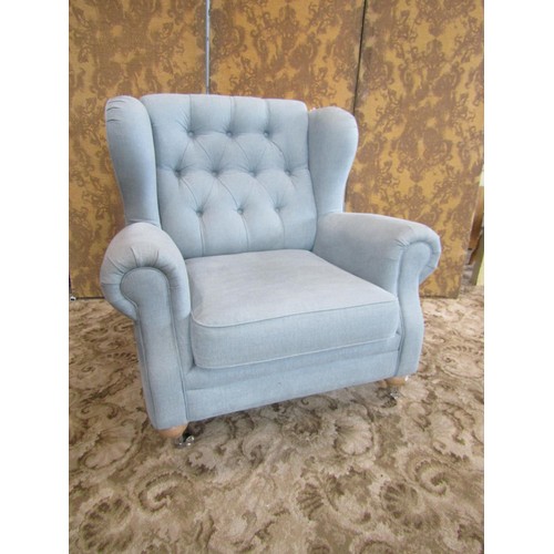 1362 - A large good quality upholstered armchair with buttoned back and rolled arms, raised on pale oak leg... 