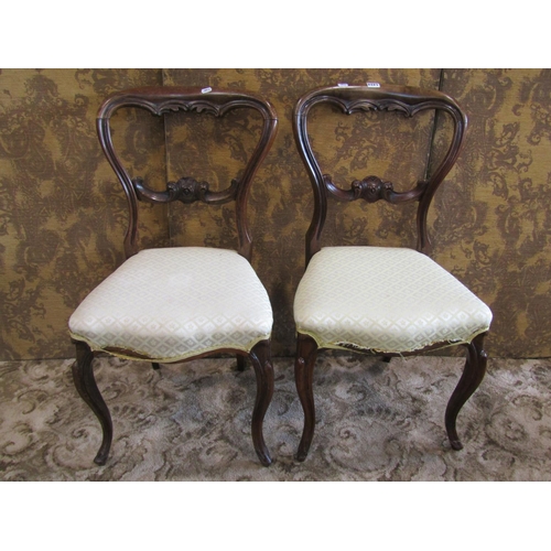 1364 - A pair of Victorian rosewood balloon-back chairs, with fixed upholstered seats in pale lemon covers.