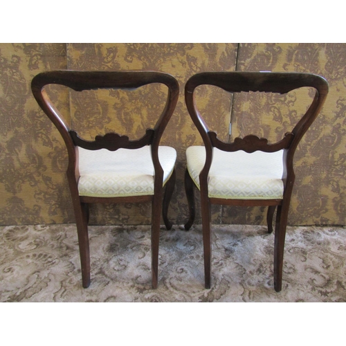 1364 - A pair of Victorian rosewood balloon-back chairs, with fixed upholstered seats in pale lemon covers.