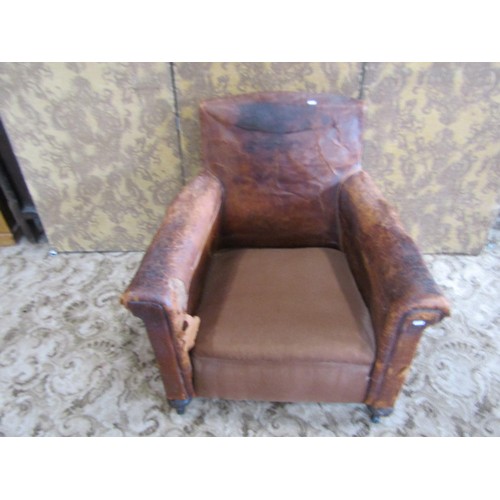 1365 - A rustic continental tan leather armchair, raised on bun supports and castors