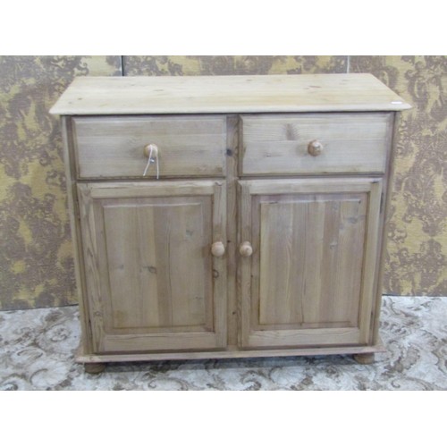 1368 - A pale pine cupboard fitted with two drawers over a pair of panelled cupboard doors revealing a shel... 