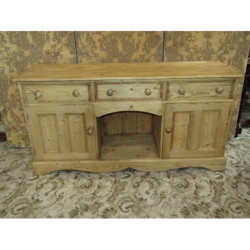 1370 - A pale pine dresser base fitted with three drawers over a pair of panelled cupboards flanking a cent... 