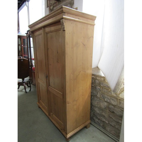 1372 - A stripped pale pine double wardrobe with carved acanthus mounts and fluted borders, 177cm high, 122... 