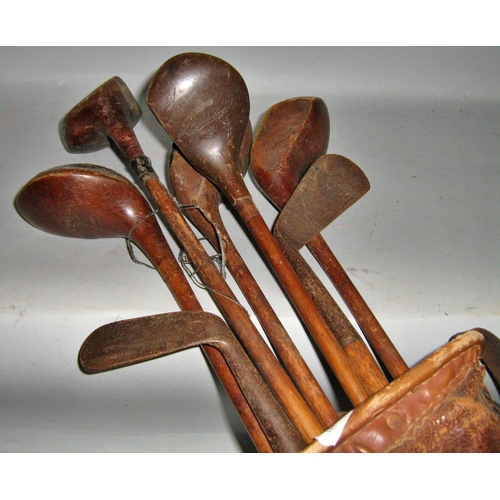 437 - A vintage collection of golf clubs, five woods, two irons and a putter and three vintage golf balls,... 