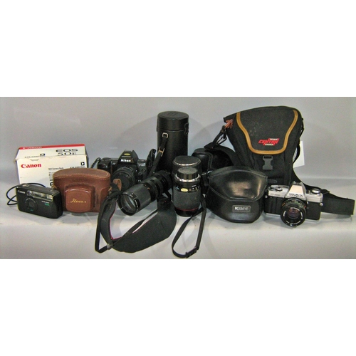 524 - A selection of late 20th and early 21st century cameras including a Canon EOS 100, a Pentax Super A,... 