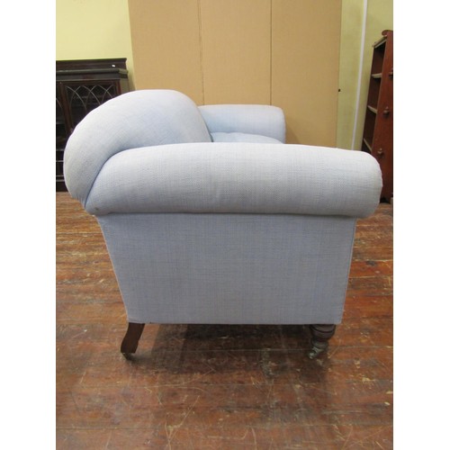 1455 - In the manner of Howard & Sons, an upholstered two seater sofa of generous proportions, with rolled ... 