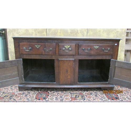 1468 - A Georgian oak drawer dresser base enclosed by three drawers and two cupboards within a panelled fra... 