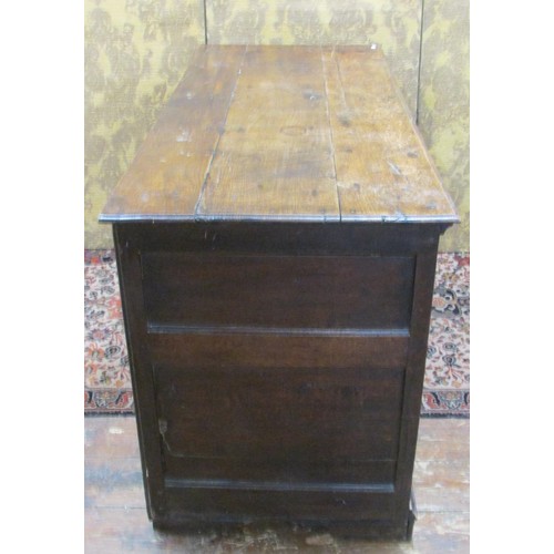 1468 - A Georgian oak drawer dresser base enclosed by three drawers and two cupboards within a panelled fra... 