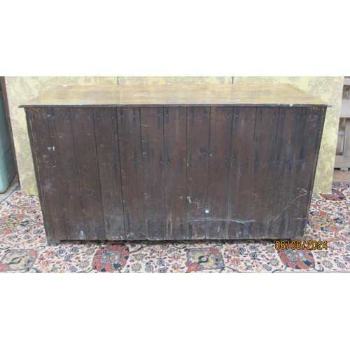 1468 - A Georgian oak drawer dresser base enclosed by three drawers and two cupboards within a panelled fra... 