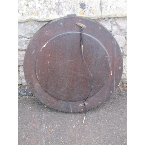 1425 - A circular stained oak framed convex wall mirror in the Art Deco style, 54cm diameter.