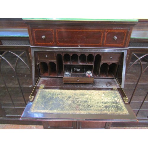 1502 - A large three part mahogany breakfront bookcase, the central writing bureau with fall flap, pigeon h... 