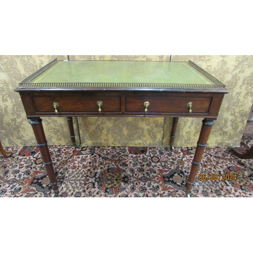 1503 - A small Regency mahogany writing table with two frieze drawers on turned and ringed supports, with i... 