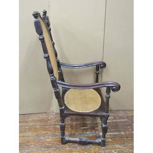 1519 - A 17th century carolean walnut elbow chair, the cane seat and back enclosed by a carved frame on tur... 