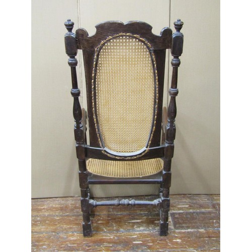 1519 - A 17th century carolean walnut elbow chair, the cane seat and back enclosed by a carved frame on tur... 