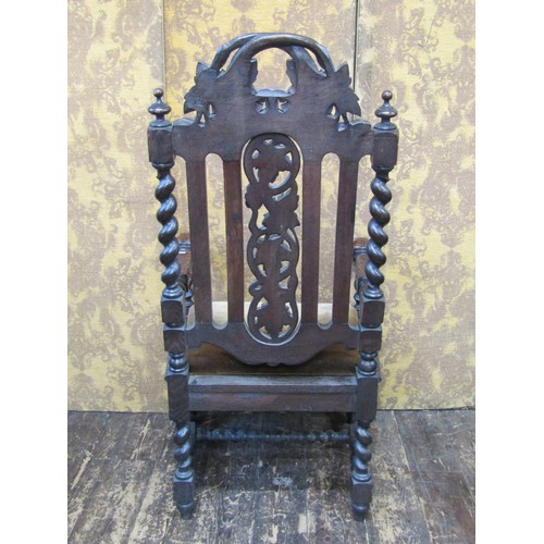 1534 - A Victorian carved oak elbow chair in the Charles II style with profusely carved detail