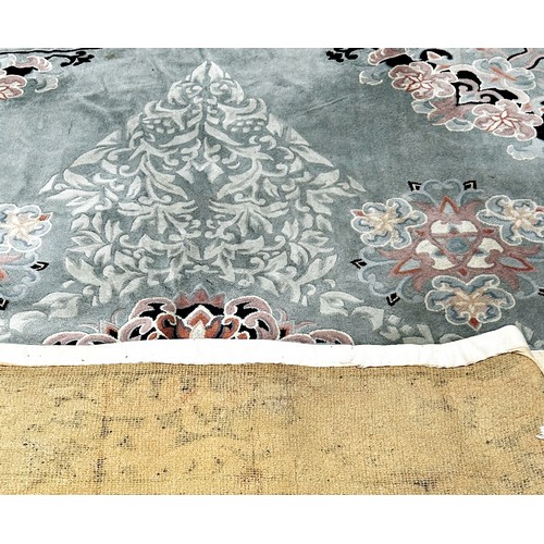 1747 - A Chinese style wool carpet with an allover floral pattern on a pale blue/green ground, 365cm x 275c... 