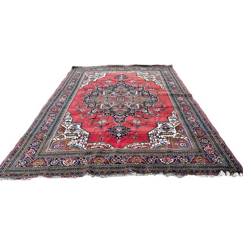 1749 - A Middle  Eastern carpet with an expansive stylised floral central medallion on a pink ground, 390cm... 