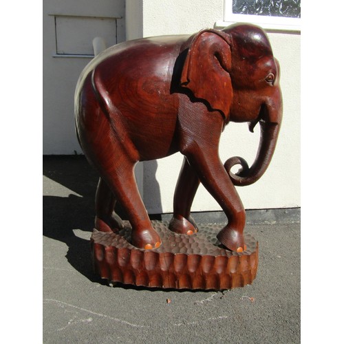 1541 - A very large and impressive carved teak elephant on adzed tablet base, 126cm tall, 93cm wide approx