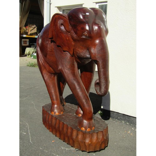 1541 - A very large and impressive carved teak elephant on adzed tablet base, 126cm tall, 93cm wide approx