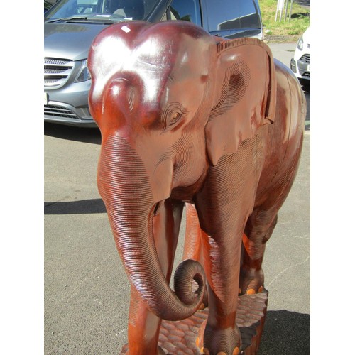 1541 - A very large and impressive carved teak elephant on adzed tablet base, 126cm tall, 93cm wide approx