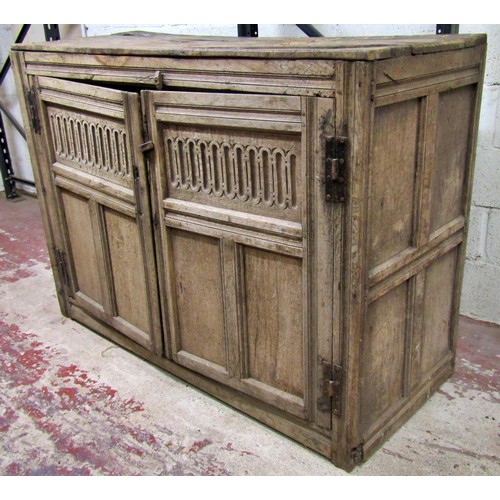 1543 - A large early oak side cupboard, with hinged panelled doors enclosing a shelved interior, 113cm high... 