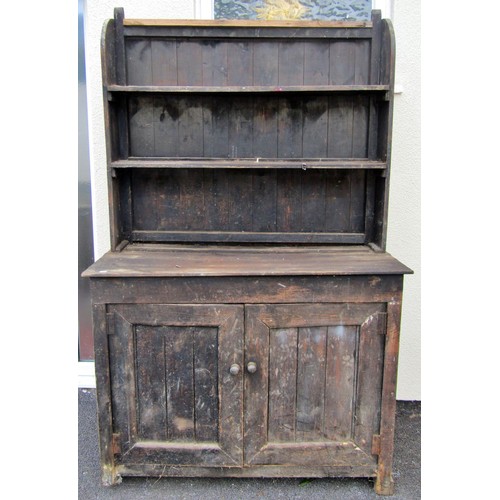 1545 - A rustic country pine dresser base with hinged panelled doors below an associated enclosed Delft rac... 