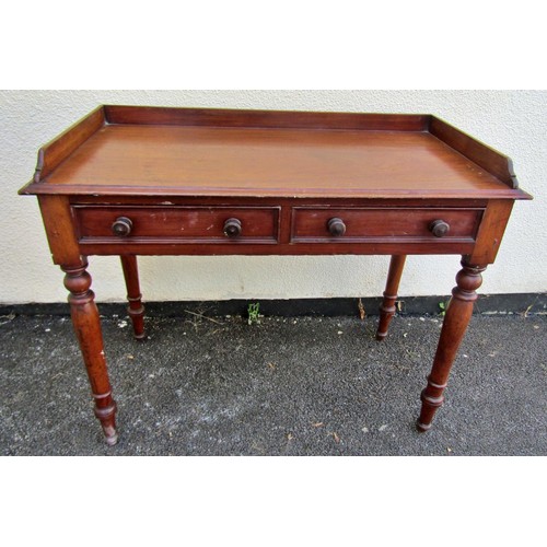 1546 - A 19th century mahogany side table with raised gallery over a pair of frieze drawers, raised on turn... 