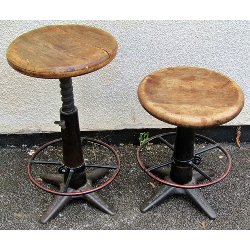 1554 - A pair of vintage industrial Singer cast iron stools, with polished timber seats and adjustable thre... 