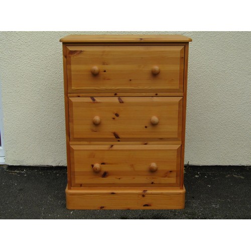 1554A - A pale pine chest of three even drawers, fitted with turned handles, 96cm high, 67 x 41cm.