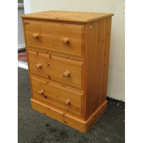 1554A - A pale pine chest of three even drawers, fitted with turned handles, 96cm high, 67 x 41cm.