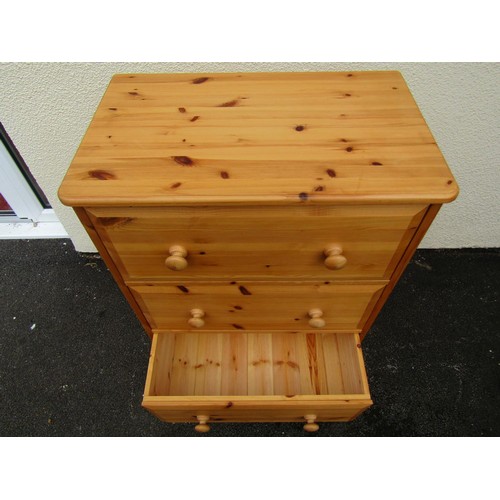 1554A - A pale pine chest of three even drawers, fitted with turned handles, 96cm high, 67 x 41cm.