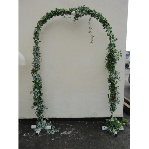 1561A - A painted square tubular steel framed wedding arch with trailing artificial ivy and floral detail, a... 