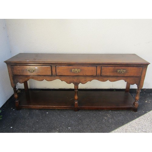 1573 - A George III design oak dresser base, fitted with three drawers over a shaped apron and platform bas... 