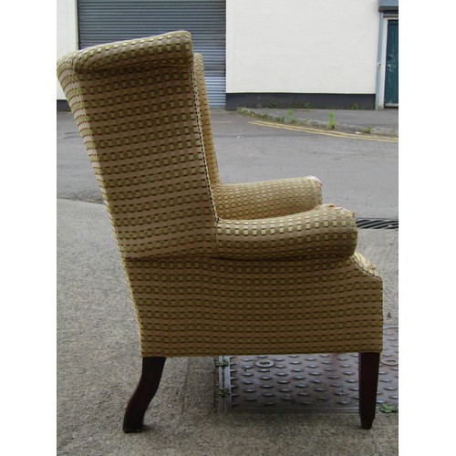 1575 - A Georgian style wing armchair with shaped outline and repeating lattice pattern upholstery, feather... 