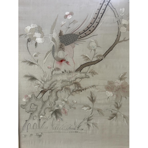 1703 - A 20th century Chinese silk embroidery depicting a pheasant perched on a branch adorned with flowers... 