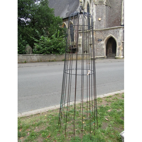 1054 - A painted and weathered steel garden obelisk of cylindrical tapered form beneath an open spiral fini... 