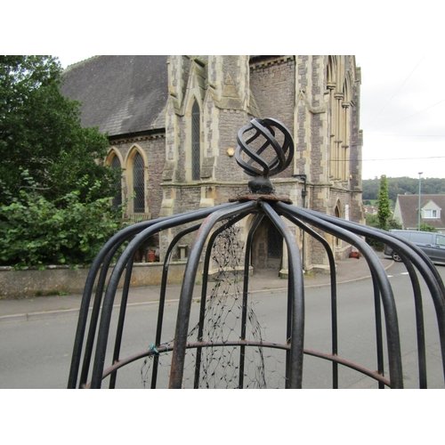 1054 - A painted and weathered steel garden obelisk of cylindrical tapered form beneath an open spiral fini... 