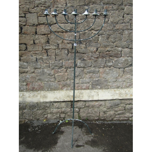 1130 - A tall floor-standing candelabra / menorah, raised on four supports with pinched feet, 151cm high, 6... 