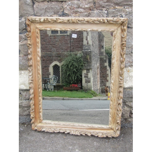 1412 - A 19th century carved limed wood framed wall mirror with foliate borders, 92 x 71cm